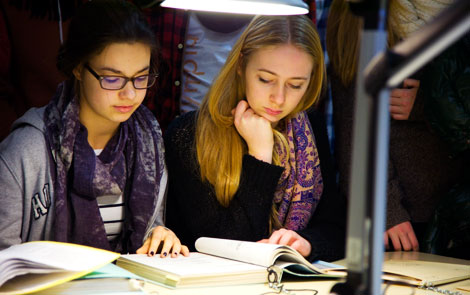 Two pupils reading sample files in the Stasi Records Agency.