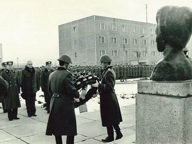 Kranzniederlegung vor der Büste Rosa Luxemburgs anlässlich ihres Todestages. Im Hintergrund ist das Stabsgebäude zu sehen. Es diente als Sitz des Kommandanten und auch die Unterabteilung der Hauptabteilung I des MfS ("Verwaltung 2000") hatte hier ihre Dienstzimmer.