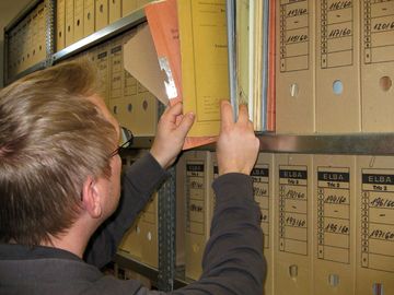 Ein Archivar sieht Aktenbände mit Stasi-Unterlagen durch