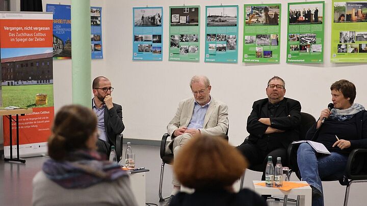 Stefan Wolle, Heide Schinowsky, Steffen Krestin und Sebastian Richter sitzen auf Stühlen und sprechen miteinander.