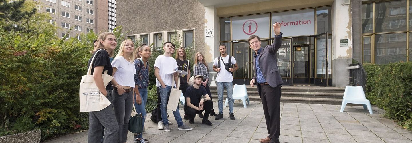 Eine Gruppe junger Menschen nimmt an einer Führung über das Gelände 'Stasi-Zentrale. Campus für Demokratie' teil.