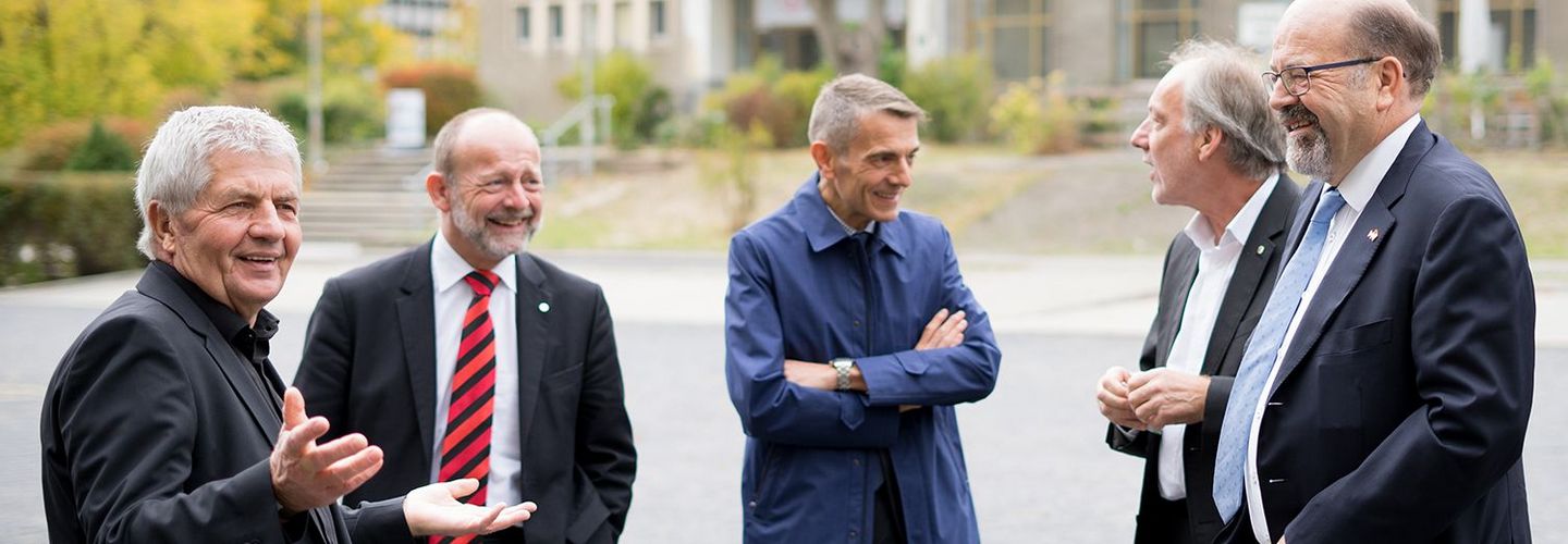 Das Bild zeigt Roland Jahn und den Schweizer Nationalratspräsidenten Dominique de Buman mit einer Delegation. Alle Personen auf dem Bild lächeln.