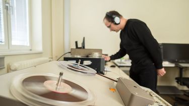 Ein Mitarbeiter des BStU mit Kopfhörern an einem Abspielgerät für Tonträger