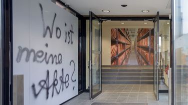 Das Bild zeigt den Eingangsbereich zur Ausstellung 'Einblick ins Geheime'. Auf einer Wand auf der linken Seite ist folgender Schriftzug zu lesen: 'Wo ist meine Akte?'