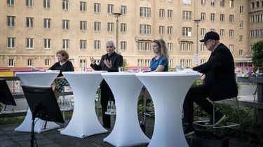 Daniela Münkel, Roland Jahn, Dagmar Hovestädt und Bernd Roth sitzen an Stehtischen. Im Hintergrund ist Haus 1 der Stasi-Zentrale zu erkennen.