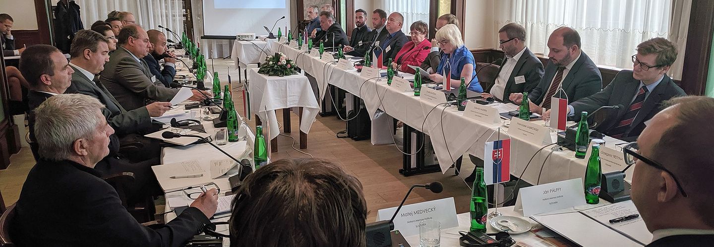 Das Bild zeigt für einen  Konferenz im Rechteck zusammengestellte Tische mit weißen Tischdecken. Die Plätze sind besetzt mit den Vertretern der osteuropäischen Geheimpolizeiarchive.