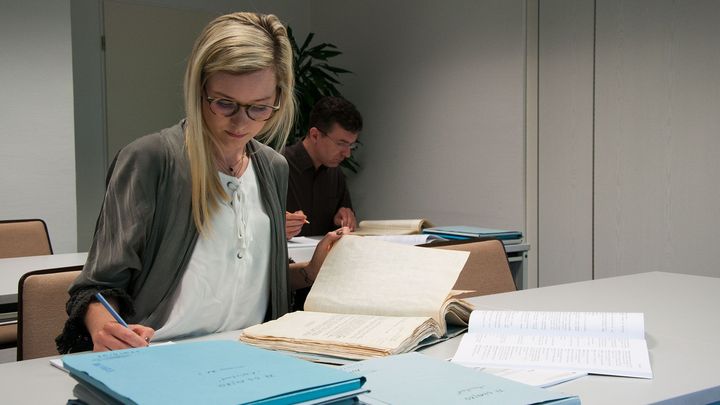 Eine Frau und ein Mann nehmen im Lesesaal des Stasi-Unterlagen-Archivs Einsicht in Stasi-Akten.