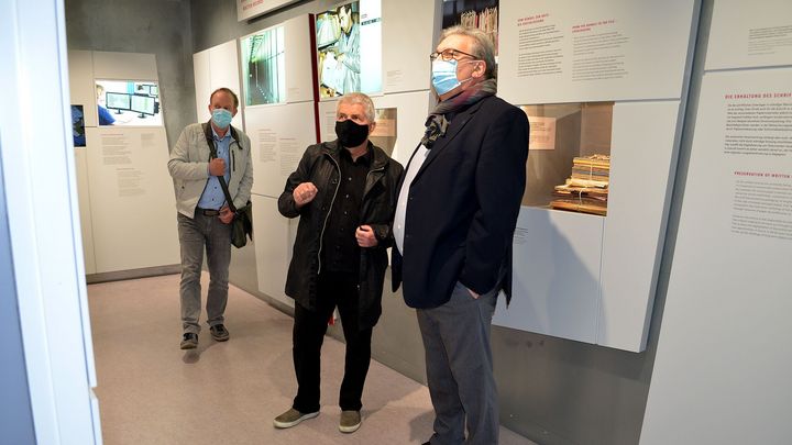 Der Berliner Aufarbeitungsbeauftragte Tom Sello, der Bundesbeauftragte Roland Jahn und der Präsident des Abgeordnetenhauses von Berlin, Ralf Wieland stehen in der Ausstellung 'Einblick ins Geheime' und schauen auf eine Ausstellungstafel. Alle drei Männer tragen einen Mund-Nasen-Schutz.