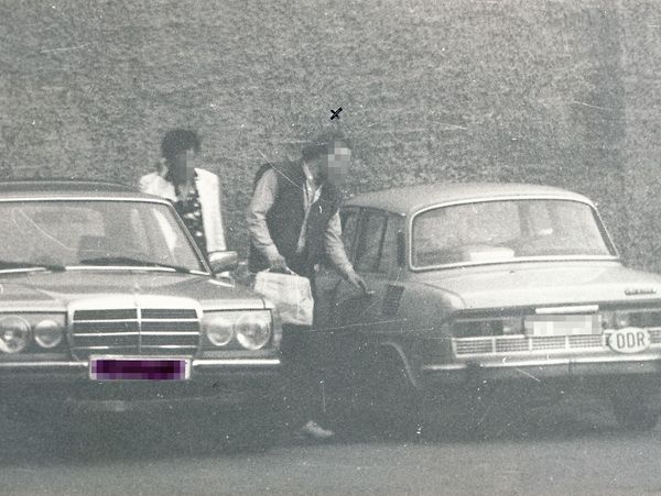 Zwei Männer zwischen zwei Autos stehend