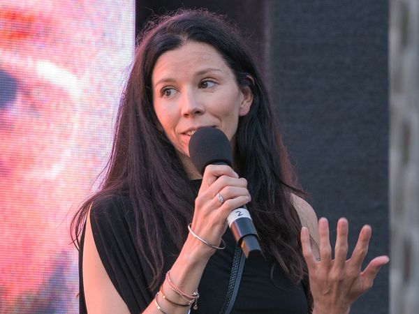 Regisseurin Franziska Stünkel hält ein Mikrofon in der Hand und spricht.