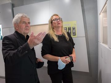 Roland Jahn und Katrin Budde betrachten in der Ausstellung "Einblick ins Geheime" eine Informationstafel.