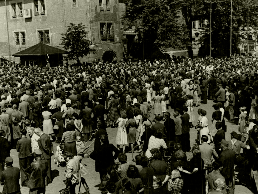 Der Marktplatz im thüringischen Sömmerda am 17. Juni 1953 mit einigen hundert Menschen. Im Hintergrund ist das Rathaus zu sehen. Auf der Rückseite des Fotos ist handschriftlich vermerkt: "Sömmerda am 17.6.53 – Marktplatz mit Rathaus und Vorplatz."