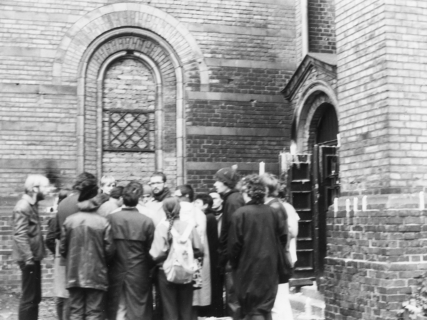 Ein Gruppe von Teilnehmerinnen und Teilnehmer einer Mahnwache steht vor der Zionskirche. Sie protestieren gegen Festnahmen in der Umweltbibliothek Ende November 1987.