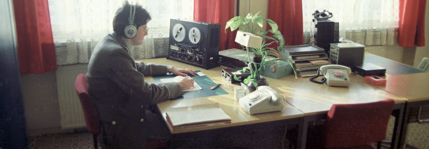Stasi-Mitarbeiter beim Abhören eines Tonbands